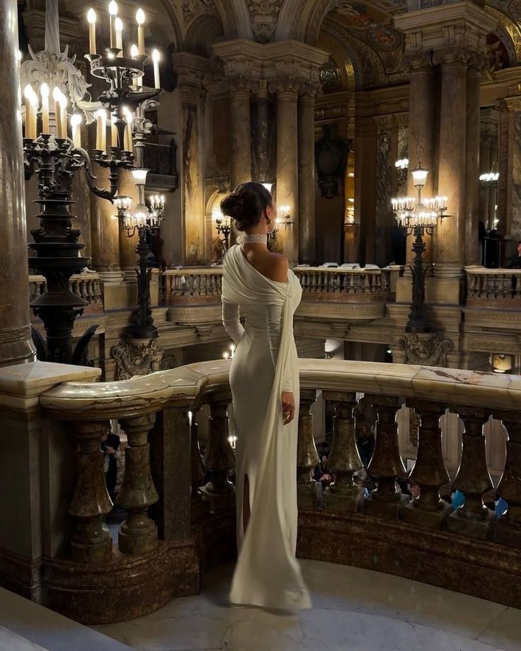 Woman in an elegant gown overlooking a grand opera hall